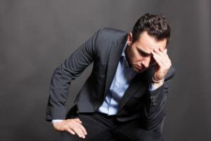 L'autosabotage dans les relations amoureuses - 5 choses à savoir- CoachAmoureux.com : un homme frustré a avec arrière plan sombre.
